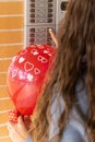 Vertical portrait of unrecognizable girl pressing the doorbell buttons at home to give her partner a surprise. celebration of a