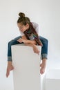 Vertical portrait in a white studio of a barefoot teenager in blue jeans and a white t-shirt