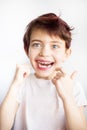 Vertical portrait of 7 years old smiling child in white t-shirt flossing his teeth on white background isolated. Healthcare and Royalty Free Stock Photo