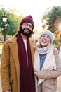 Vertical portrait of a young adult lovely couple smiling and laughing looking at camera, wearing scarf, hats, coats and Royalty Free Stock Photo