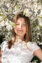 Vertical portrait of a young attractive woman in the flowered garden. Smile with her eyes closed Royalty Free Stock Photo