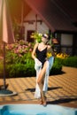 Vertical portrait of young beautiful sexy tanned slim blonde woman in sunglasses and bandage on hair with standing in black Royalty Free Stock Photo