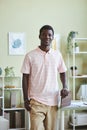 Black man smiling at camera standing by desk in office Royalty Free Stock Photo