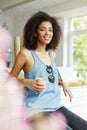 Vertical portrait of young good-looking cheerful dark-skinned africal female student with wavy hair in blue shirt Royalty Free Stock Photo