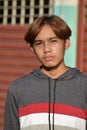 Vertical portrait of a young Southeast Asian boy with a serious facial expression outdoors Royalty Free Stock Photo