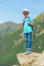 Vertical portrait of a young traveler with a backpack high in th