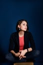 Vertical portrait of a young woman blogger or copywriter with a pencil behind her ear ponders new ideas