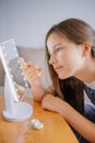 Vertical portrait Young woman trying to apply contact lenses in front of mirror. Young girl trying on new contact lenses. Close up Royalty Free Stock Photo