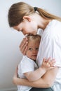 Vertical portrait of young woman mother kissing baby girl daughter on hands at home Royalty Free Stock Photo