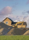 Vertical Puffy clouds at sunset Construction sand piles with two excavators at Utah