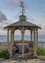 Vertical Puffy clouds at sunset Gazebo with built in seat and table in a beautiful garden at La
