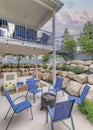 Vertical Puffy clouds at sunset Outdoor patio with blue armchairs and fire pit in the middle