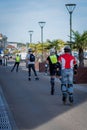 Vertical rear shot of a group of roller riders in the port of Pornic