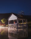 Vertical of the reflection of a dock house in a mirror lake captured against the dark night sky Royalty Free Stock Photo