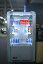 Vertical refrigerator banquet cabinet presented, cans Pepsi and Coca Cola inside. Trade and Industry exhibition