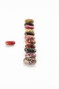 Vertical row of multicolored beans on white background. Twelve raw kidney beans. Close-up