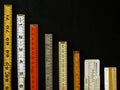 Vertical row of old rulers suggests a graph of decreasing return