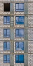 Vertical Row of the windows of apartment building in development state with reflections of blue sky in window glass Royalty Free Stock Photo