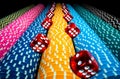 Vertical rows of colored casino chips and many red dice on isolated black background. Set of yellow, blue and pink Royalty Free Stock Photo