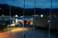 Vertical rows of luminous garlands against the background of a dark city and mountains