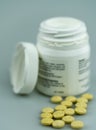 Selective focus close up of white prescription pill bottle and yellow pills Royalty Free Stock Photo