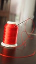 Vertical selective focus of a red spool of thread and a needle Royalty Free Stock Photo