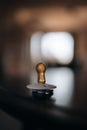 Vertical selective focus shot of a bronze baby pacifier on a table
