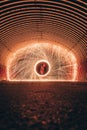 Vertical selective focus shot of burning circle and burning wave at night in an underground tunnel