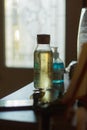 Vertical selective focus shot of a clear bottle of yellow liquid on a table Royalty Free Stock Photo