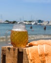 Vertical selective focus shot of a decorative glass of cold beer at a beach Royalty Free Stock Photo