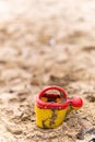 Vertical selective focus shot of a small watering can on the sand Royalty Free Stock Photo