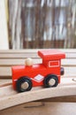 Vertical selective focus shot of a toy red wagon on a wooden table Royalty Free Stock Photo