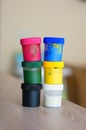 Vertical selective focus shot of two colorful paint container stacks on a table Royalty Free Stock Photo