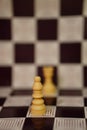 Vertical selective focus shot of a white bishop on a chessboard