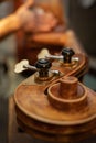 Vertical selective focus of the violin pegs on the scroll during the luthiery Royalty Free Stock Photo