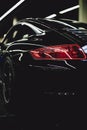 Vertical selective shot of the taillight of a black sports car Royalty Free Stock Photo