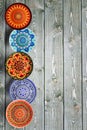 Vertical Set of decorative ceramic plates hand painted dot pattern with acrylic paints on a gray wooden background. Copy space Royalty Free Stock Photo