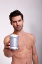 Vertical shoot of cool bare guy with deodorant in right hand