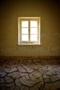 Vertical shot of abandoned house interior with cracked clay on the floor and peeling paint