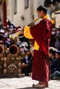 Vertical shot of an Adult Tibetan Buddhist worshiper with a ritual horn at the Tiji Festival