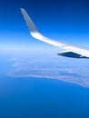 Vertical shot of the airplane flying obove the Southern California coastline Royalty Free Stock Photo