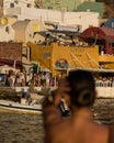 Vertical shot of the Ammoudi bay at sunset time with fish taverns and a blurred woman behind it