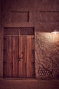 Vertical shot of an ancient Arabic wooden door illuminated by lamp at night Royalty Free Stock Photo