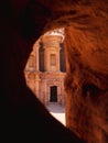 Vertical shot of an ancient archeological temple at historical Petra in Jordan seen through a cave