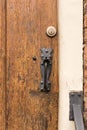 Vertical shot of ancient iron door handle in wooden front door Royalty Free Stock Photo