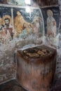 Vertical shot of an ancient tank on old Peeled wall with religious painting of Christianity Royalty Free Stock Photo