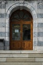 Vertical shot of an arched wooden door in a concrete building Royalty Free Stock Photo