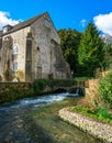 Vertical shot of the Arlington Mill by the river in Bibury, UK