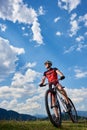 Athletic professional sportsman bicyclist in sportswear and helmet standing with cross country bike
