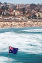Vertical shot of the Australian flag at the sea in a crowded Bondi beach Royalty Free Stock Photo